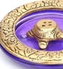 Gold Metal Tortoise Incense Holder Placed In Purple Glass Vessel