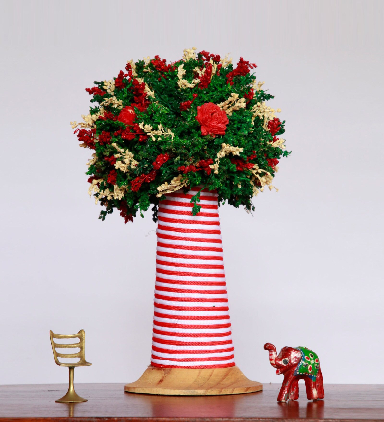 Green Tree With Sola Flowers On A Conical Coir Stem And Wooden Base